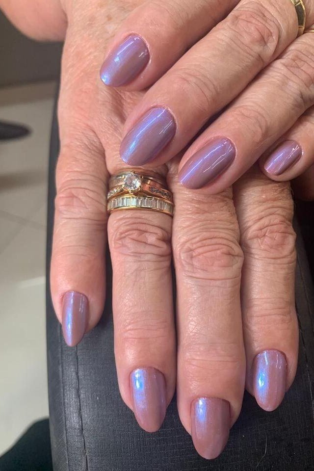 Mauve Oval Nails on Mature Hands with Gold Rings, elegant mauve nail idea for women over 60