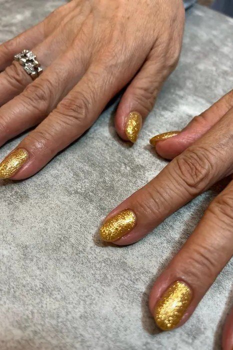 Gold Glitter Nails on Mature Hands for women over 60