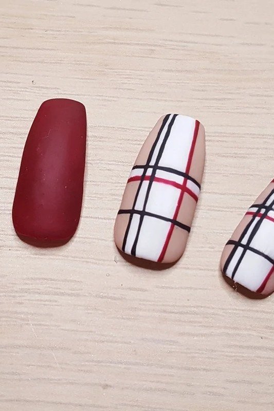 Dark burgundy with plaid short, gold rings, burgundy fall nail idea for women over 60