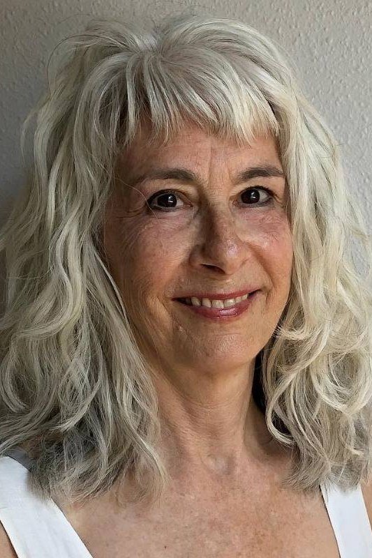 Curly silver-white haircut on an older woman, front view, medium hairstyle for women over 60