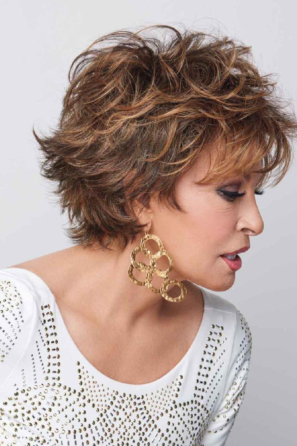 curly brown pixie with hoop earrings for women over 50 side view