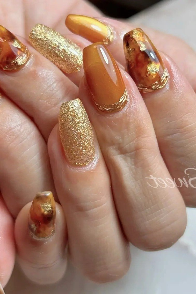 Caramel gel nails with tortoiseshell art and gold glitter, warm fall manicure