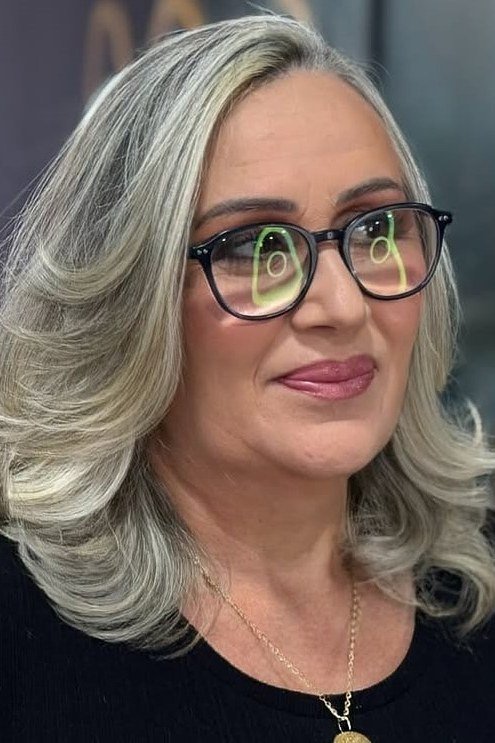 Wavy silver-gray hair with glasses on an older woman, front view, medium hairstyle for women over 60