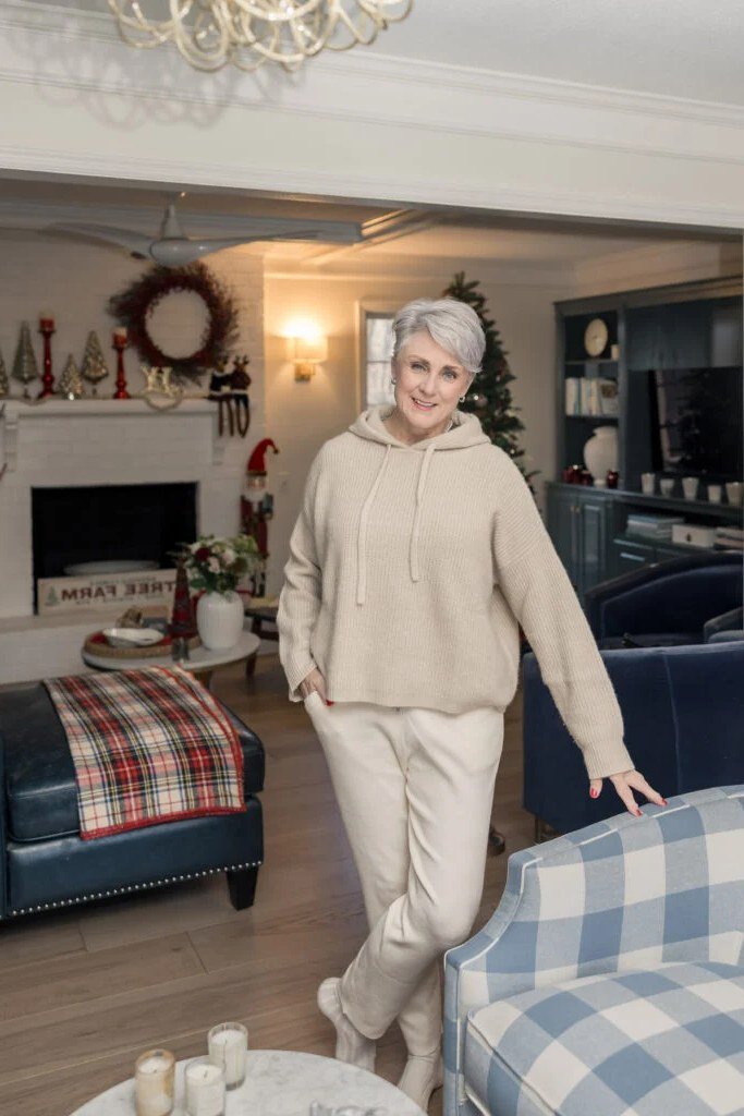 Woman over 50 wearing Beige hoodie with matching sweatpants in a living room.