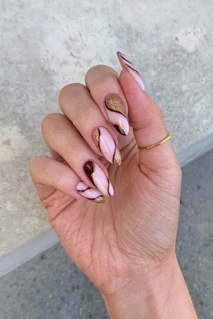 Nude nails with burgundy and gold swirl art