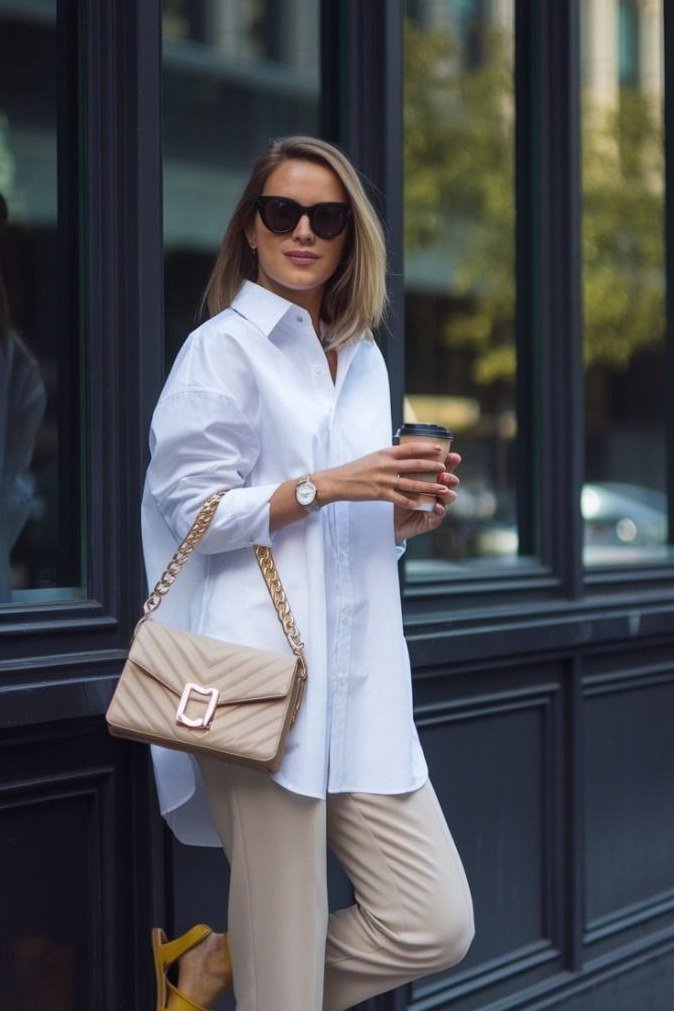 White shirt beige trousers, blonde woman with sunglasses on street - business casual work outfit for women over 50