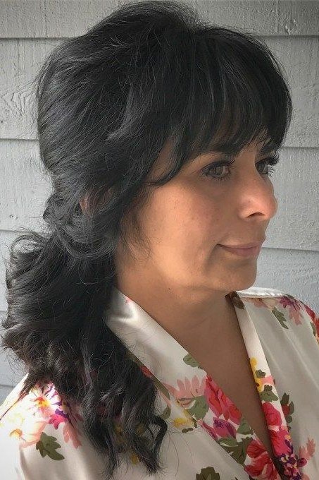 Long dark half-up hair with bangs and volume for women over 50