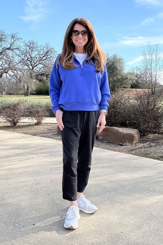 Woman over 50 wearing royal blue sweatshirt with black joggers, everyday casual outfit idea