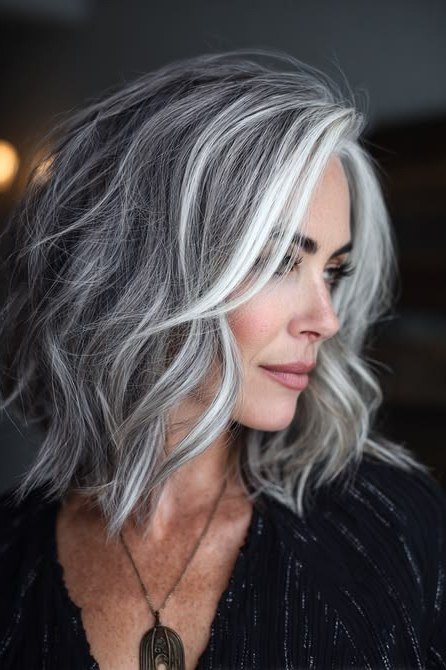 silver-grey wavy layered bob, side view — chin-length layered bob hairstyle for women over 50