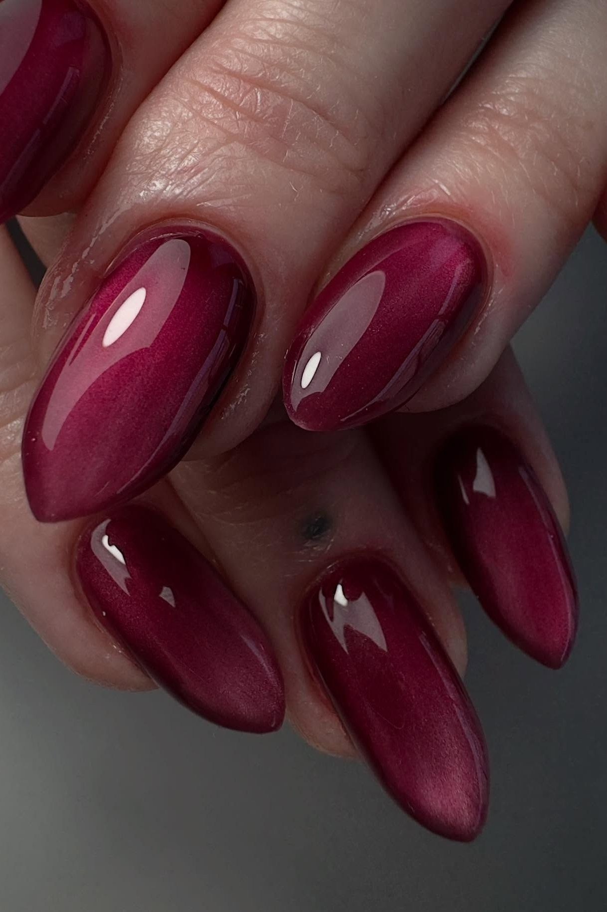 Magenta cat-eye almond, burgundy fall nail idea for women over 60
