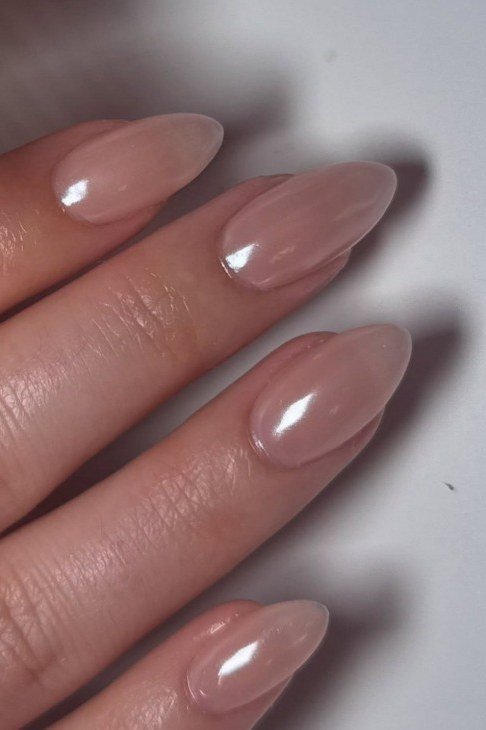 Glossy nude pink almond nails closeup for women over 50