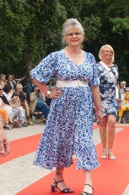 Two women in blue floral dresses posing on a red carpet - summer dress for women over 50