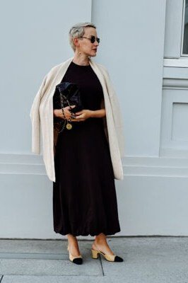 dark brown midi dress with ivory cardigan over shoulders for women over 50