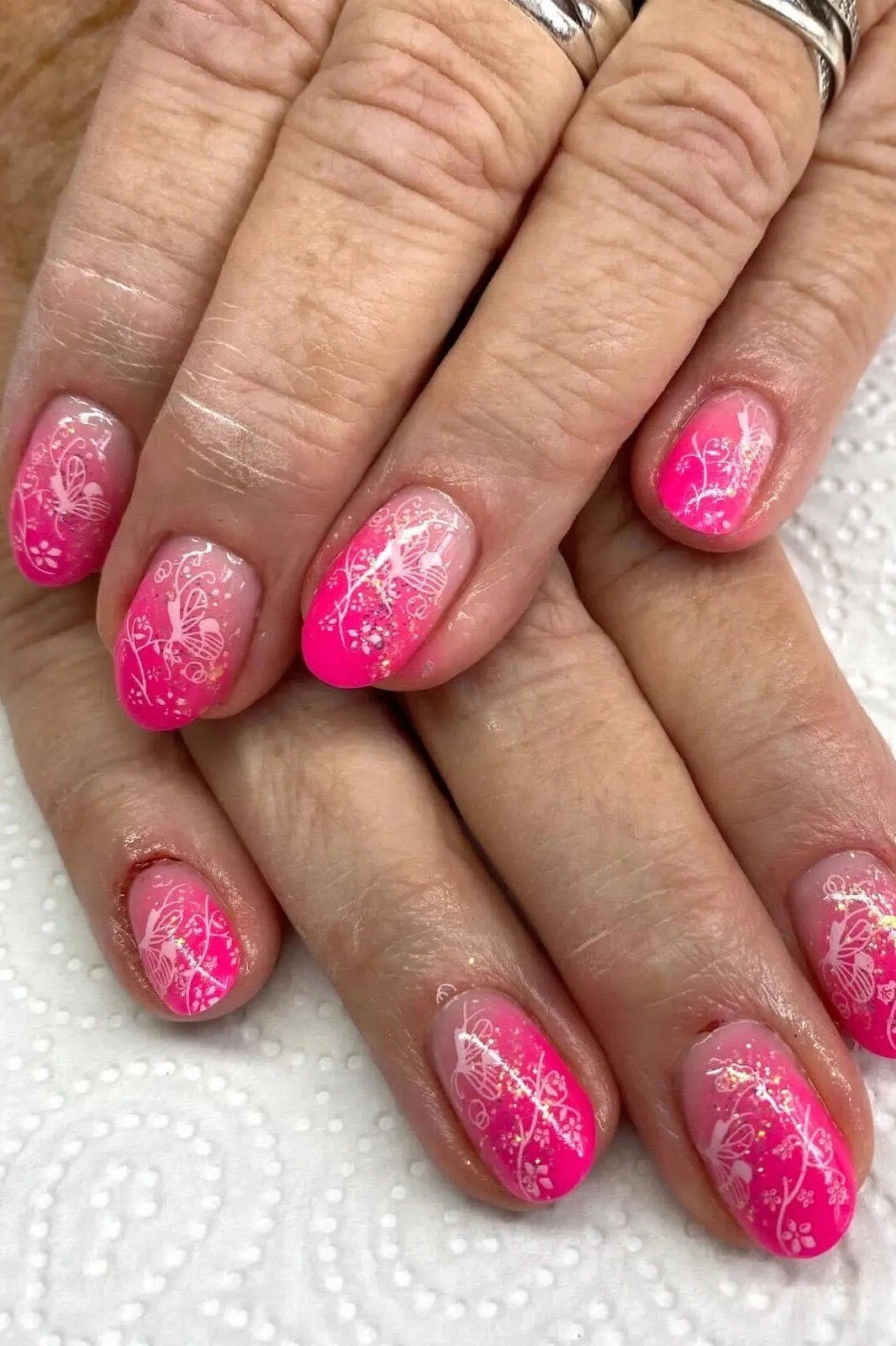 Hot pink glitter ombre on mature hands, short nails, ombre nail design for women over 60