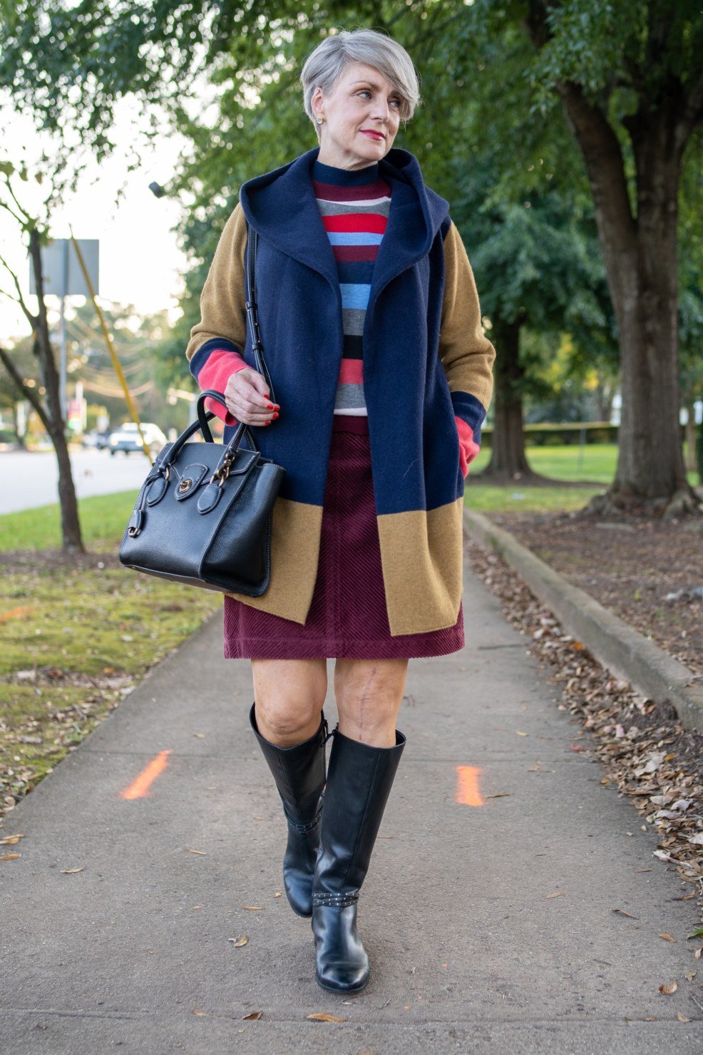 Elegant fall outfit for women over 70: camel coat with burgundy skirt and boots