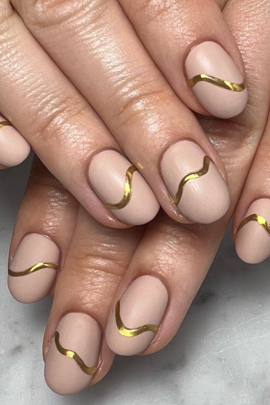 Nude nails with gold line art on mature hands