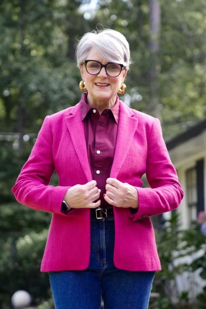 Older woman in fuchsia blazer magenta shirt and jeans
