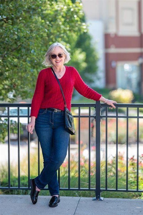 Red v-neck sweater with dark jeans and black crossbody bag