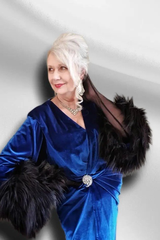 holiday evening outfit for women over 60: royal blue velvet dress with black fur stole