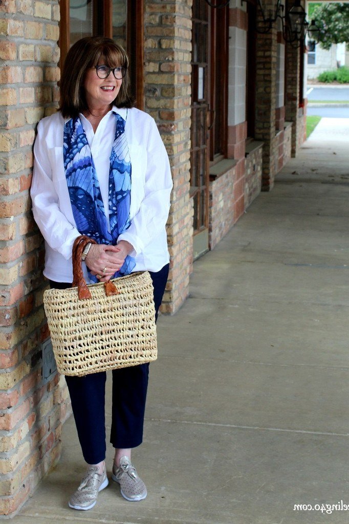 White Shirt with Blue Scarf, Dark Jeans, and Straw Bag - chic casual outfit for women over 50