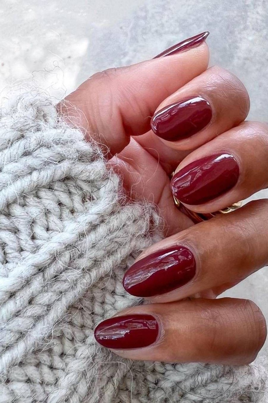 Deep Red Oval Nails with a Chunky Knit, fall nail color idea for women over 50