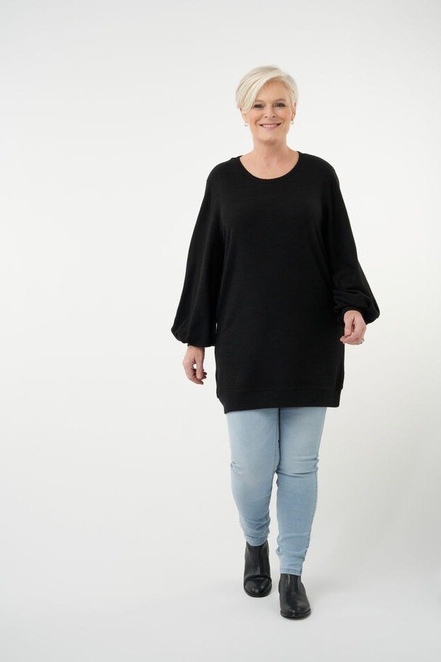 Black oversized tunic with light wash jeans and black ankle boots