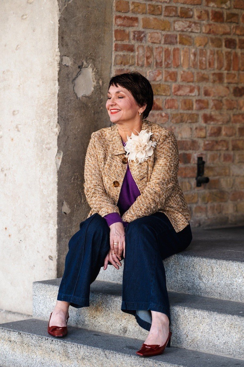 Gold tweed jacket with navy trousers fall outfit idea for women over 60