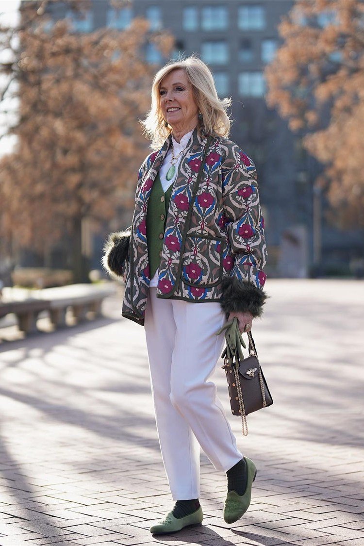 Fall city outfit for women over 50: colorful embroidered jacket white trousers