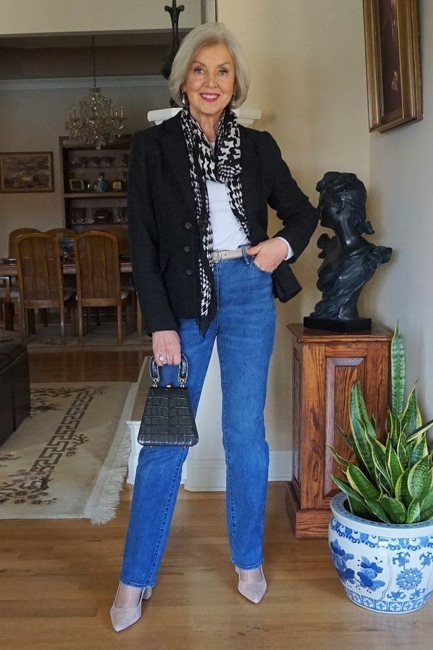 Older woman in black blazer with leopard scarf and blue jeans