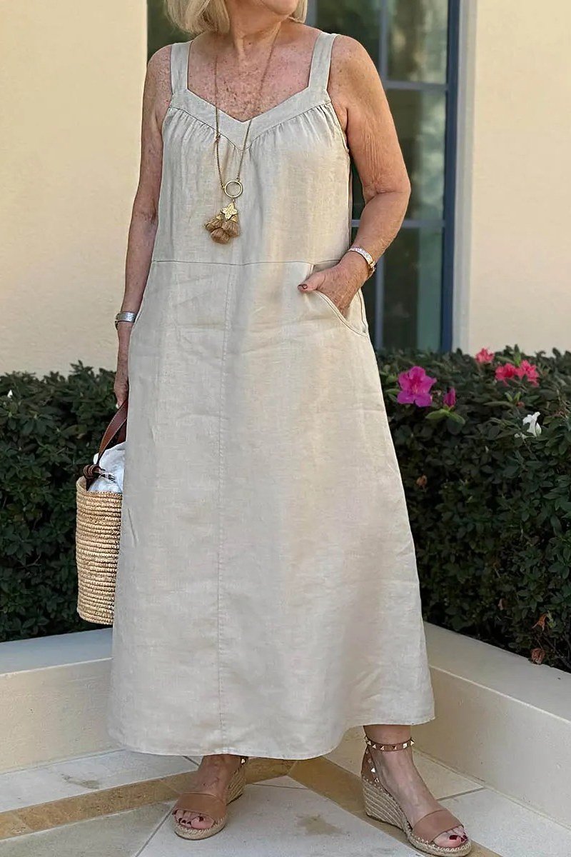Woman in a white linen maxi dress with a long necklace, patio - summer dress for women over 50