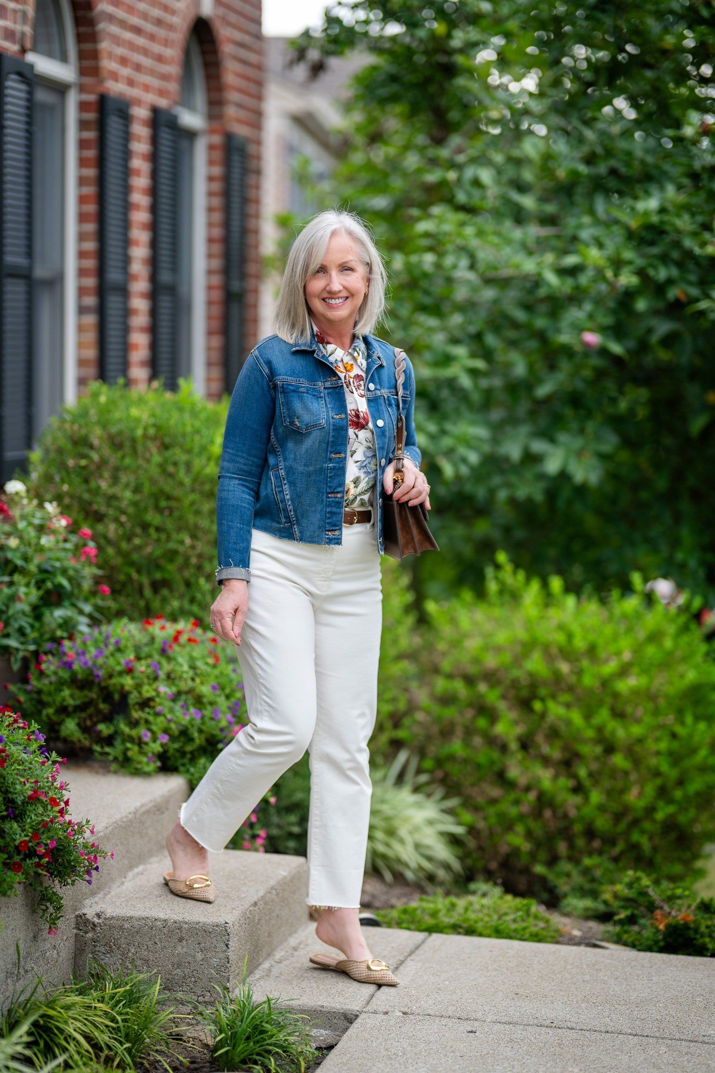 Denim jacket with floral blouse and white jeans in garden