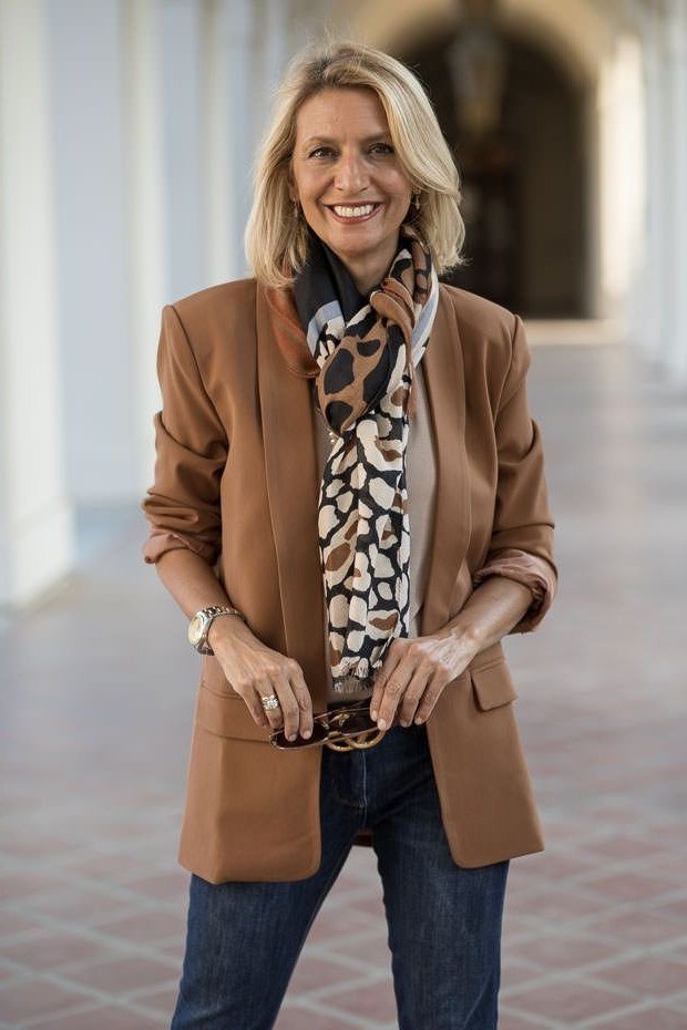 Tan blazer with leopard print scarf and dark jeans for women over 60