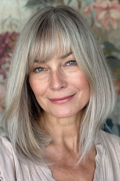 silver-gray straight layered medium with curtain bangs for women over 60