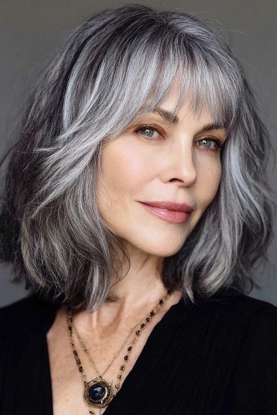 silver-gray shaggy layered medium with curtain bangs for women over 60