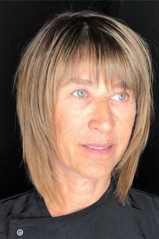 sleek straight blonde layered bob with bangs for women over 60