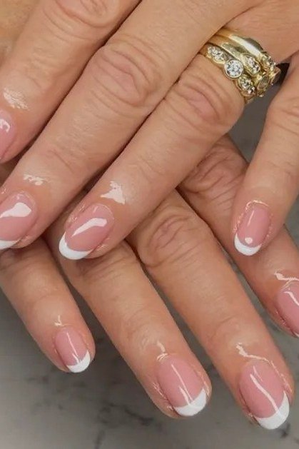 French manicure on mature hands with a gold ring