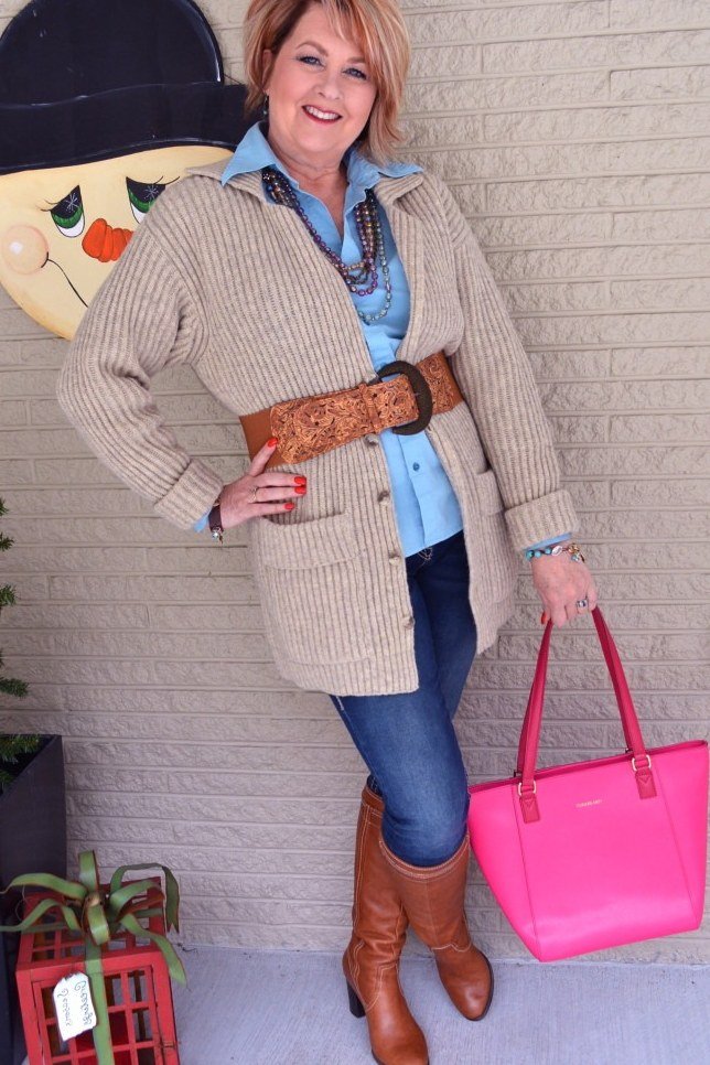 Fall city outfit for women over 50: beige cardigan blue shirt jeans brown belt tan boots pink tote