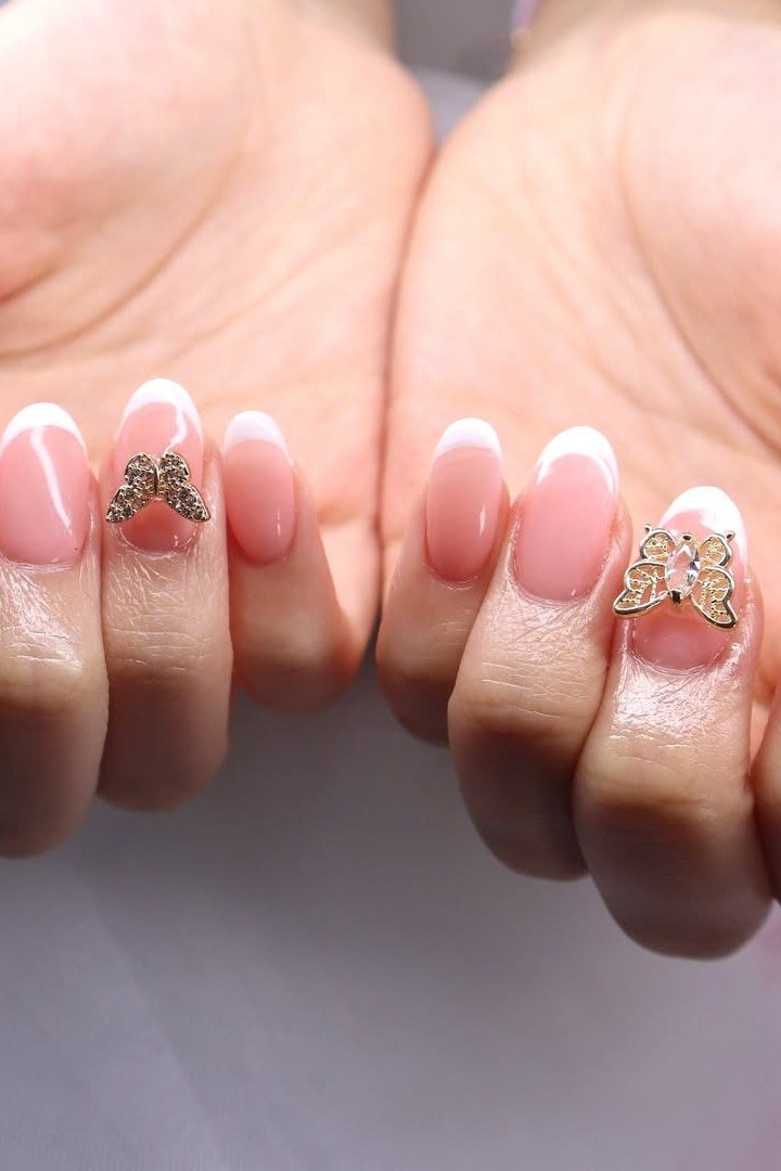 French nails with butterfly charm accents