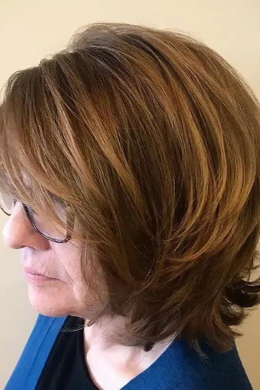 Layered Brown Wedge With Glasses on a woman over 50 - flattering wedge haircut idea