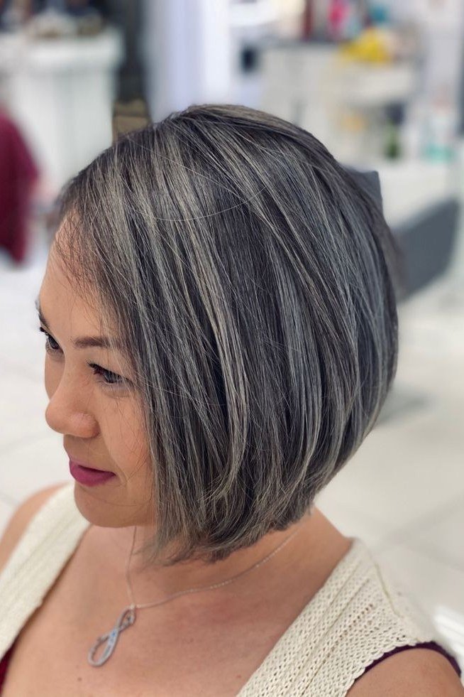 Salt-and-pepper short asymmetric bob with deep side part and longer front panel