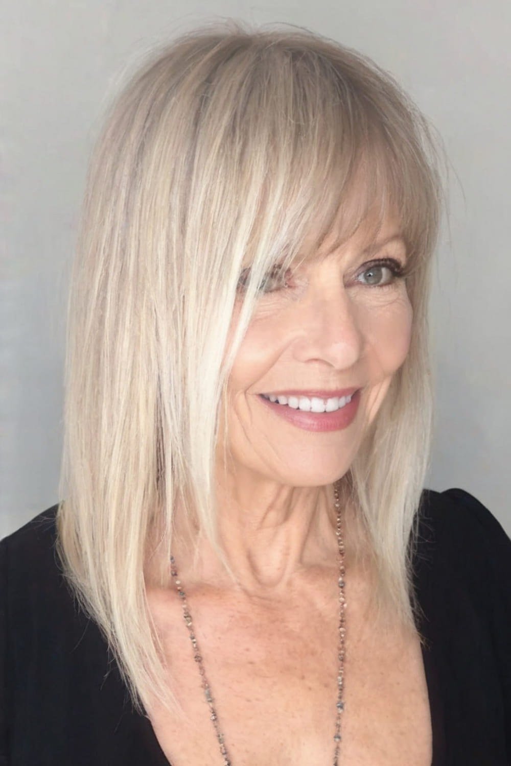 Platinum Blonde Straight Layered Cut with Bangs for Women Over 40