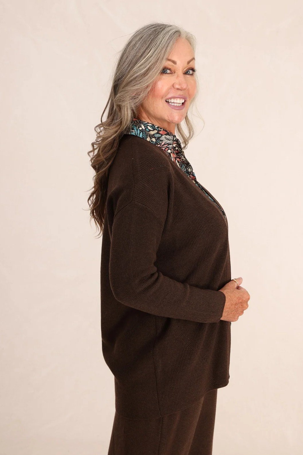 Older woman wearing a chocolate brown cardigan with brown pants