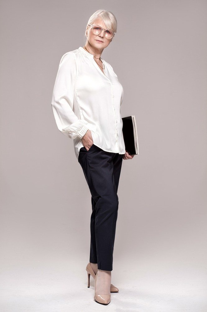 White blouse with navy slim trousers, professional look for women over 60