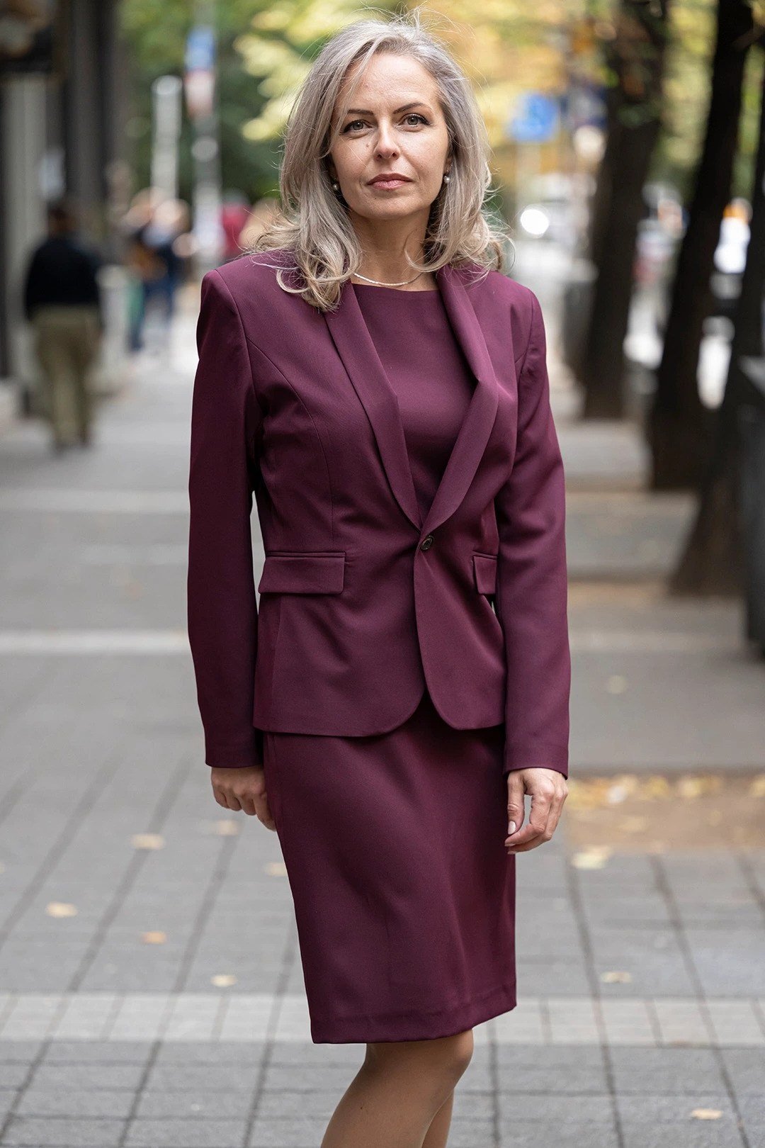 Burgundy blazer and pencil skirt suit, city street