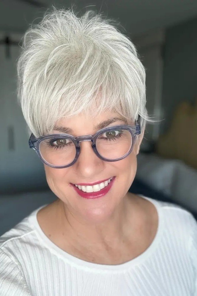 Spiky white pixie haircut with black rimmed glasses for older women