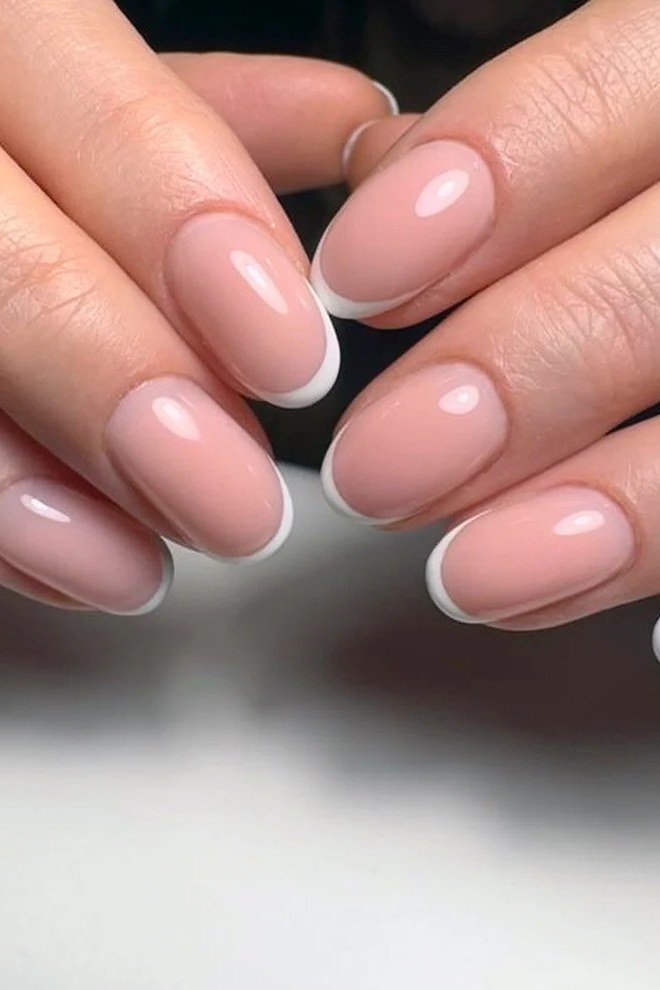 French tip close-up with pink base and crisp white smile line, builder gel nails for women over 50