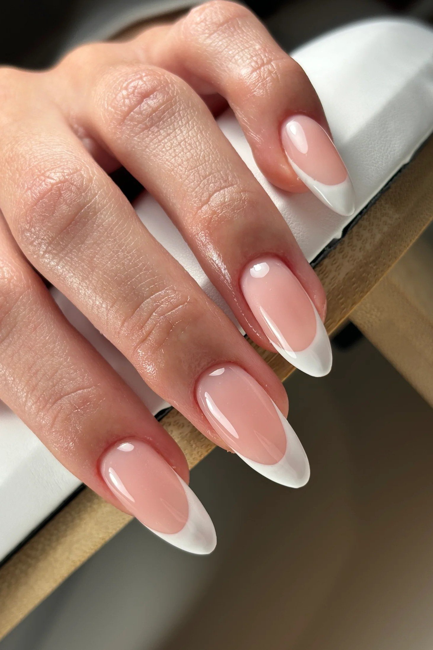 Almond French nails with white tips, glossy finish, ring on finger, for women over 50