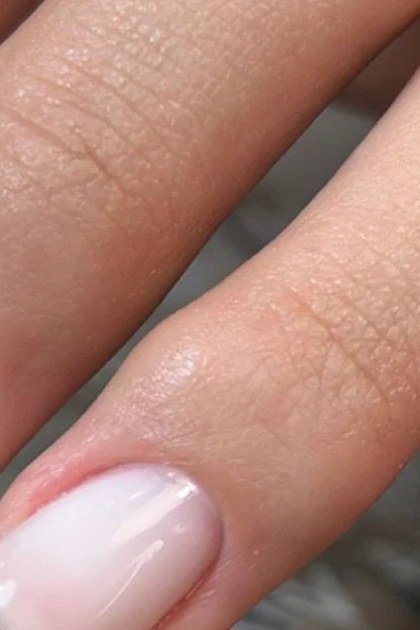 Milky French ombre with soft white tips on medium square nails, women over 50