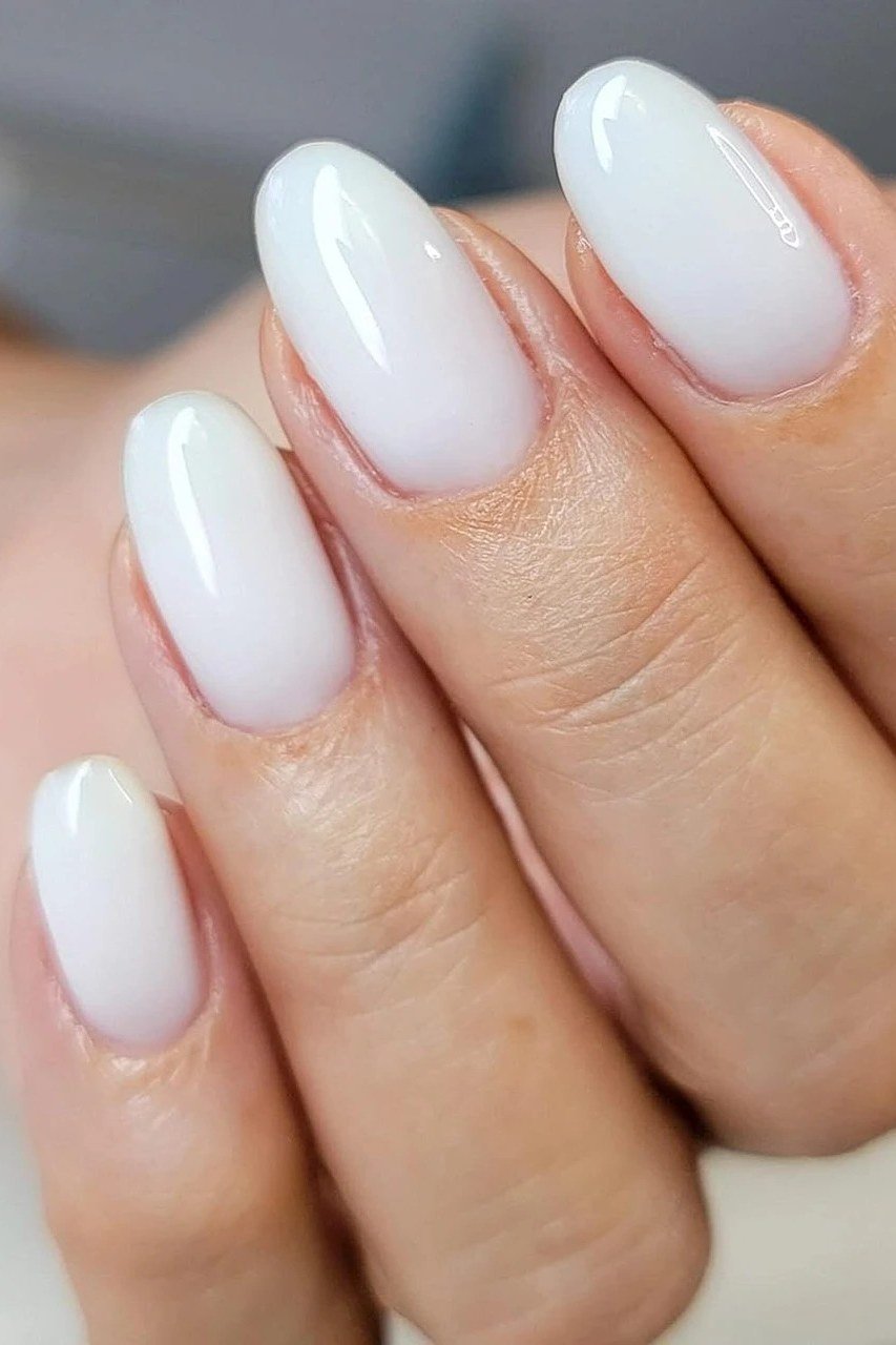Milky white builder gel on medium almond nails with glossy finish, women over 50
