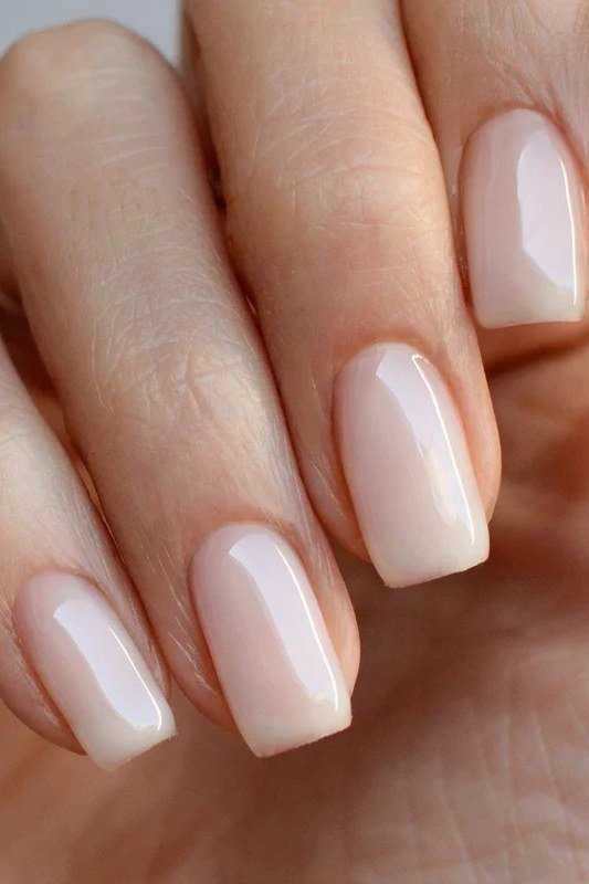Milky white medium square nails on neutral background, builder gel for women over 50